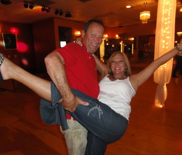 A couple in a playful hold, the man lifting his partner’s leg
