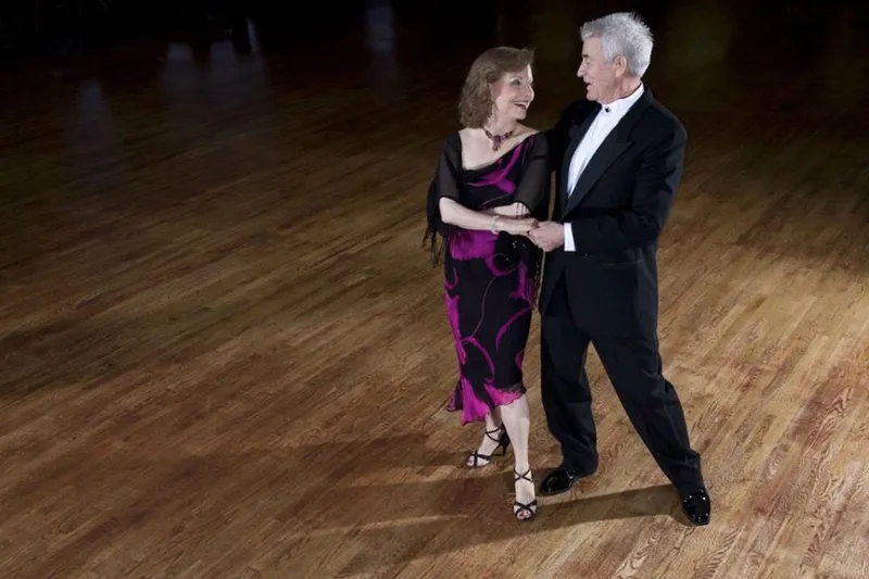 An older couple dancing together on the studio floor