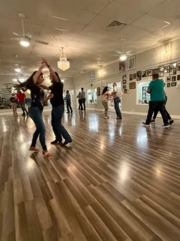 A group class working through a step across the floor