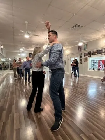 A couple dancing while the rest of the class practises behind them