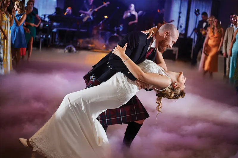 A performer dipping his partner on stage under dramatic light
