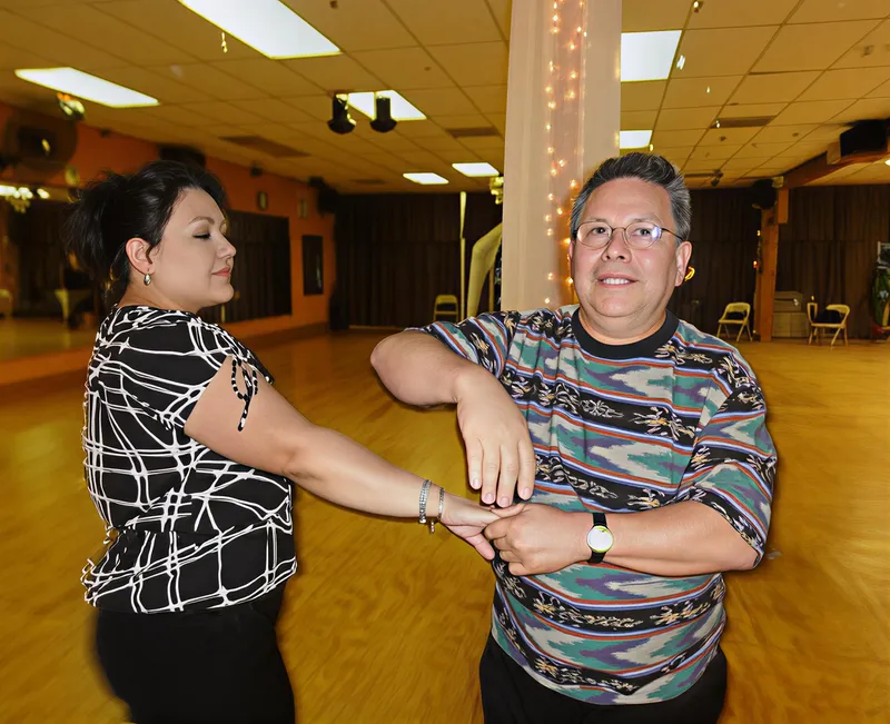 A couple laughing in a dance hold at a party